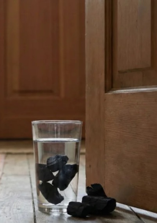 Poucos sabem qual o sentido de colocar carvão em um copo atrás da porta