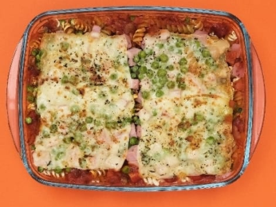 Macarrão Preguiçoso é receita prática preparada diretamente no forno. Prato leva molho de tomate, ervilha, presunto e queijo e fica pronto em poucos minutos. Veja